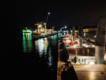 Boats moored at harbor in city at night
