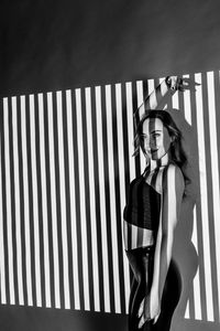 Portrait of woman standing against wall