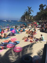 People at beach against clear sky