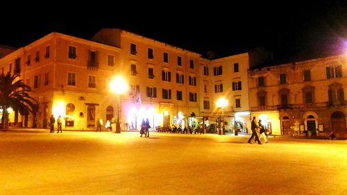 People playing in illuminated city at night