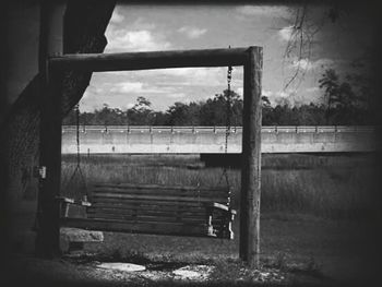 Empty field against cloudy sky