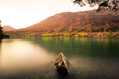 Scenic view of lake by mountains against sky
