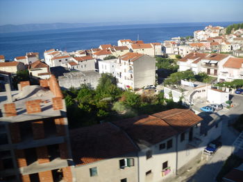 High angle view of townscape by sea against sky