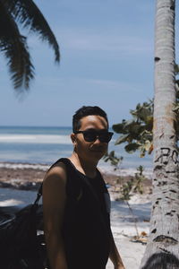 Portrait of man wearing sunglasses standing against sky