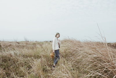 Boy on field against clear sky