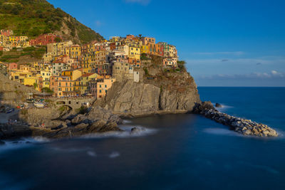Scenic view of sea by buildings against sky