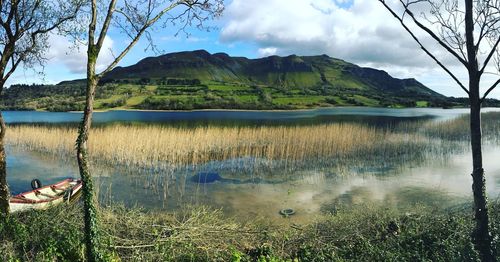 Scenic view of lake by mountains against sky