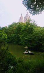 People on lake against trees