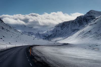 Snow covered road passing through mountains