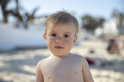 Portrait of cute baby boy standing outdoors