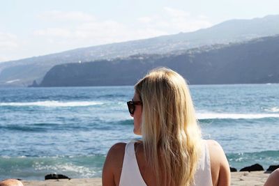 Rear view of young woman standing at beach