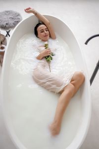High angle view of woman lying in bathroom