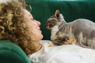 Woman with cat lying on bed at home