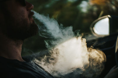 Close-up of man smoking in car