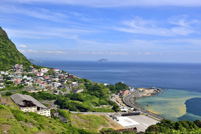 High angle view of cityscape by sea against sky