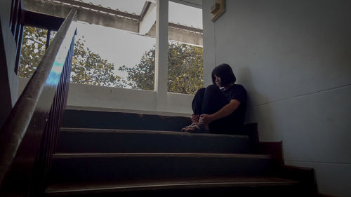 Man sitting on staircase of building