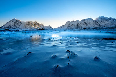 Scenic view of snowcapped mountains against blue sky