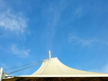 Low angle view of circus tent against blue sky during sunny day