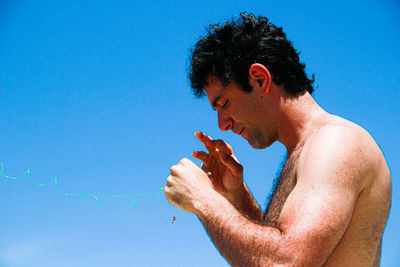 Portrait of young man holding blue sky