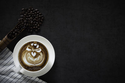 Coffee cup on table against black background