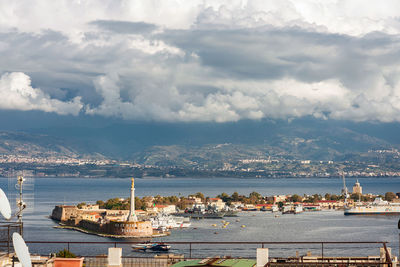 Cityscape by sea against sky