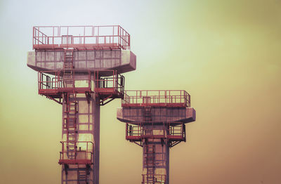 Low angle view of communications tower against sky during sunset