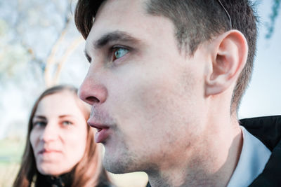 Close-up of young man talking with woman at park