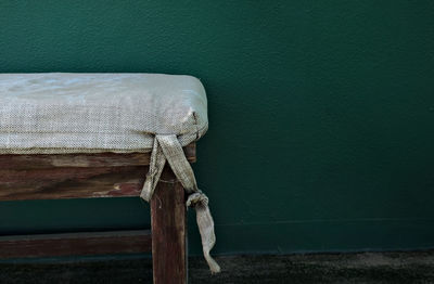 Close-up of wooden table against green wall