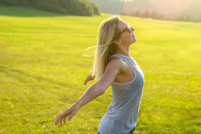 Portrait of young woman standing on field