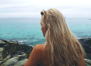 Rear view of woman looking at sea against sky
