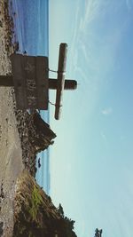 Low angle view of text on beach against sky