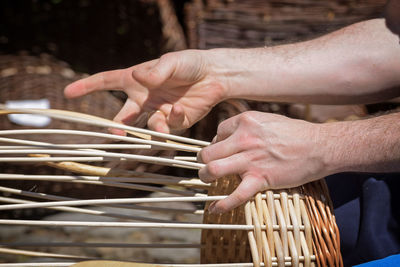 Cropped hands midsection of man making wicker basket