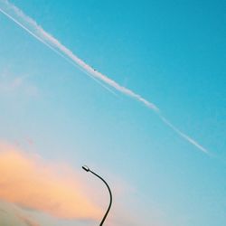 Low angle view of vapor trail against blue sky