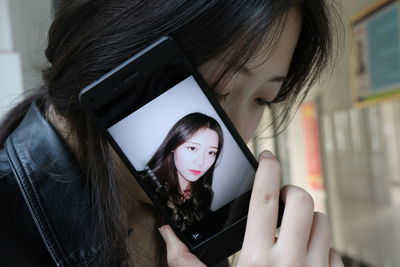 Close-up of young woman using mobile phone at home