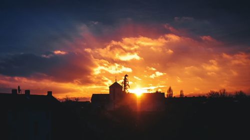 Silhouette buildings against sky during sunset