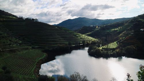 Scenic view of river and mountains against sky