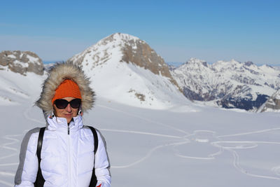 Portrait of person with snowcapped mountains in winter