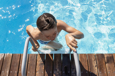 High angle view of shirtless boy in swimming pool