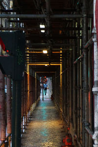 Rear view of man walking in tunnel