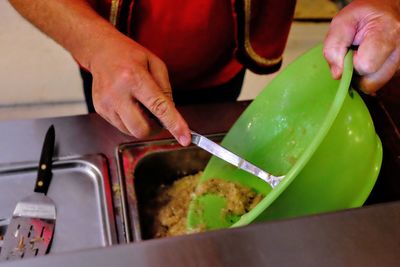 Midsection of man putting food in container