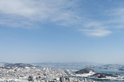 Aerial view of cityscape against blue sky