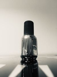 Close-up of glass bottle on table against white background