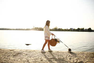 Woman walking on the beach with pet cat