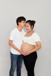 Friends standing against white background