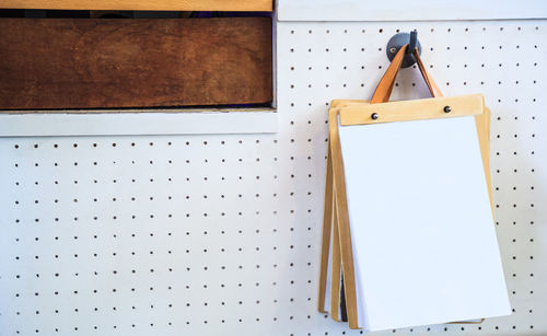 Close-up of notepad hanging on pegboard