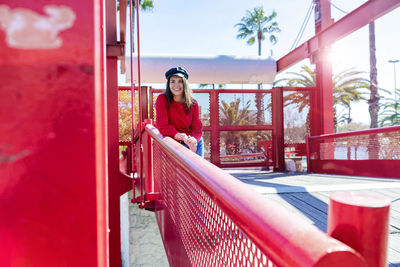 Smiling teenage girl wearing red top in city during sunny day