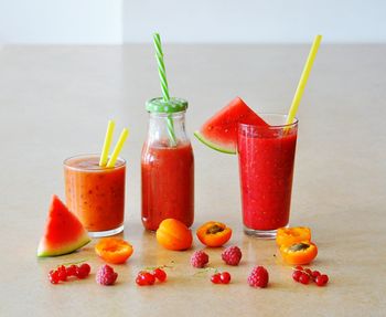 Fruits with berry smoothies on table