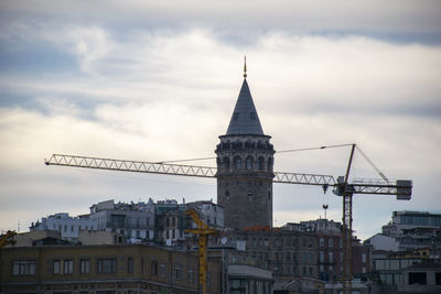 Galata tower buildings in city against cloudy sky