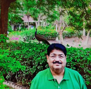 Portrait of smiling man standing against plants