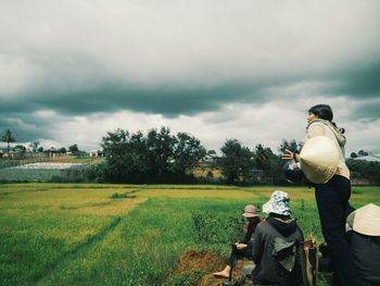 Rear view of man on field against sky